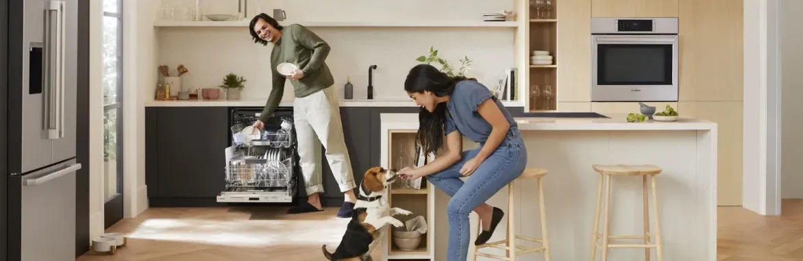 man unloading dishwasher and women feeding dog